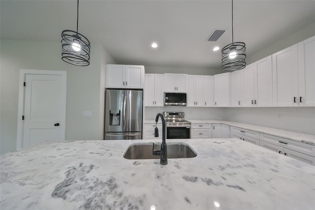 kitchen with stainless steel appliances, decorative light fixtures, white cabinets, and sink