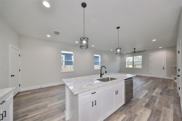 kitchen featuring sink, white cabinets, dishwasher, ceiling fan, and a kitchen island with sink