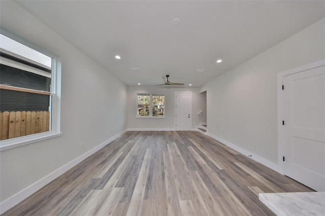 unfurnished living room featuring ceiling fan and light hardwood / wood-style flooring