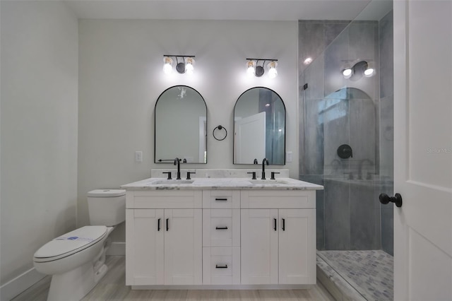 bathroom with vanity, tiled shower, toilet, and hardwood / wood-style floors