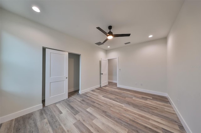 unfurnished bedroom featuring ceiling fan, light hardwood / wood-style flooring, and a closet