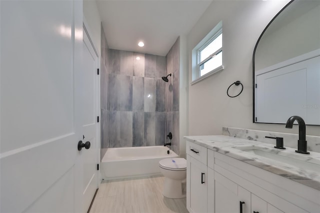 full bathroom with toilet, vanity, and tiled shower / bath