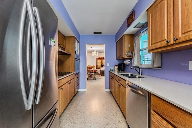 kitchen featuring appliances with stainless steel finishes, sink, and a notable chandelier