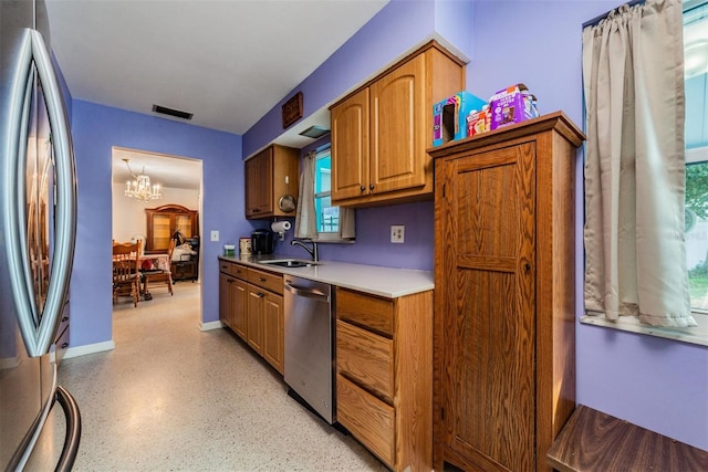 kitchen with sink, a notable chandelier, and stainless steel appliances