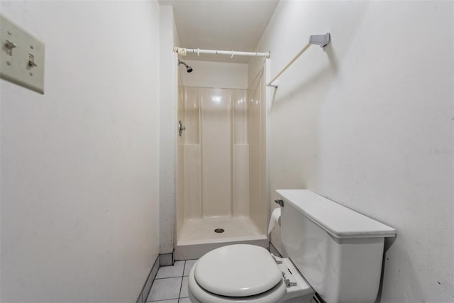 bathroom with toilet, a shower, and tile patterned flooring