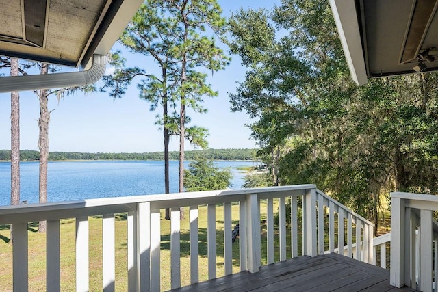 wooden deck featuring a water view and a lawn