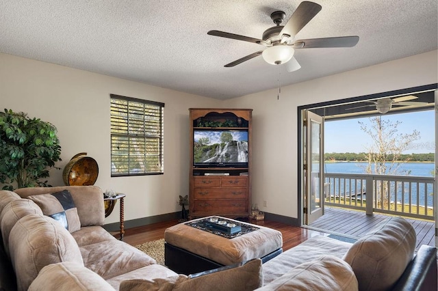 living room featuring dark hardwood / wood-style floors, plenty of natural light, and ceiling fan