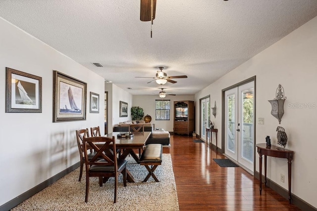 dining room with dark wood-type flooring, a textured ceiling, french doors, and ceiling fan