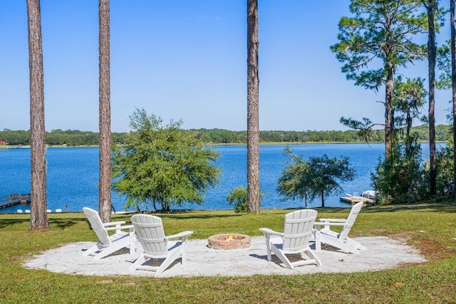 view of yard featuring a water view and an outdoor fire pit