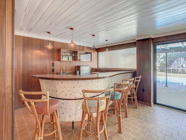 bar with wood walls, pendant lighting, and wood ceiling