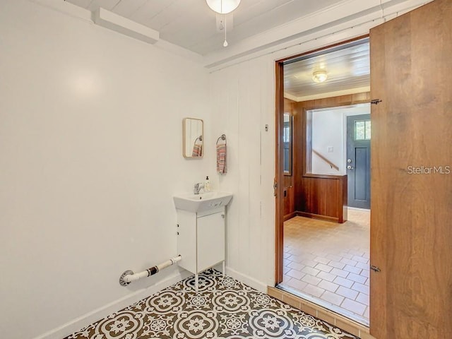 bathroom with wood walls, tile patterned flooring, and vanity