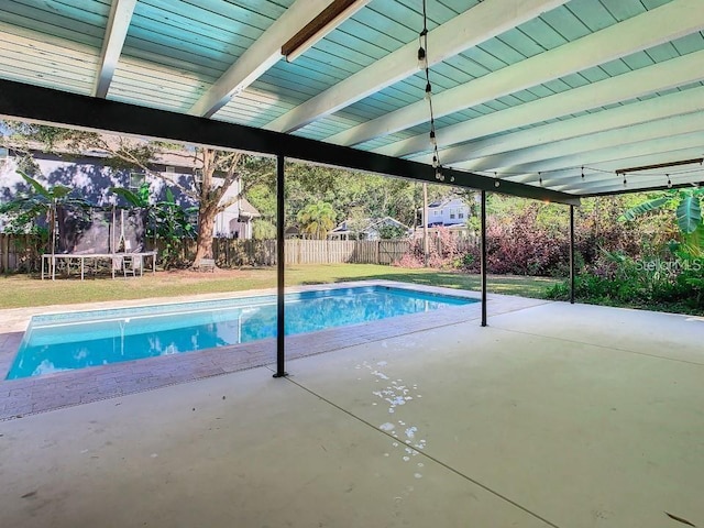 view of swimming pool featuring a patio, a lawn, and a trampoline