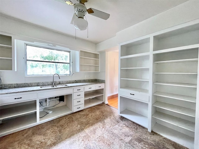 kitchen featuring sink, white cabinets, and ceiling fan