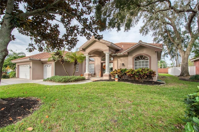 mediterranean / spanish home with a garage and a front yard