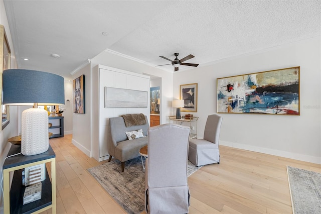 interior space featuring light hardwood / wood-style floors, crown molding, a textured ceiling, and ceiling fan