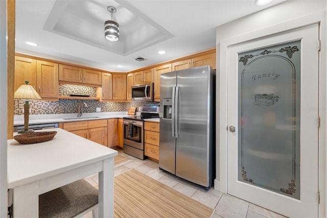 kitchen with light brown cabinetry, sink, a raised ceiling, stainless steel appliances, and decorative backsplash