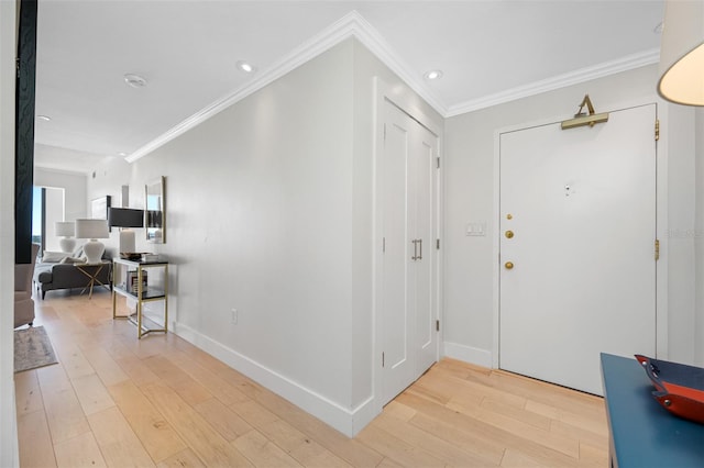 foyer featuring ornamental molding and light wood-type flooring