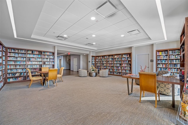 carpeted home office with a raised ceiling