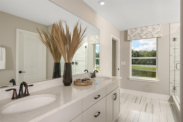 bathroom featuring vanity, a water view, and a shower with door