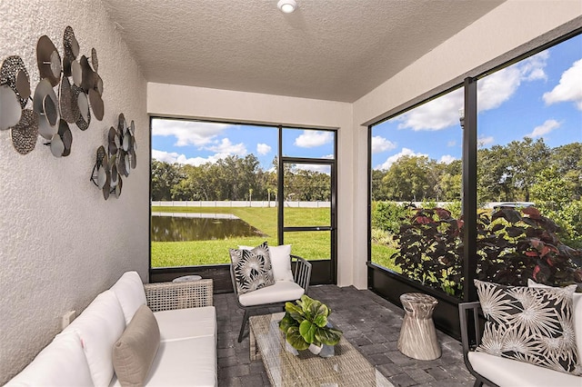 sunroom / solarium featuring a water view