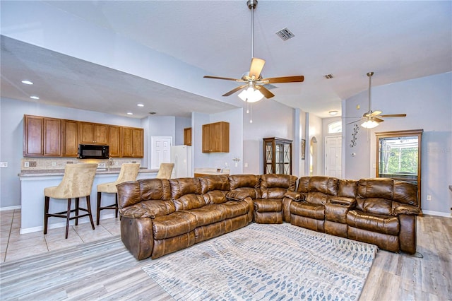 living room featuring ceiling fan and light wood-type flooring