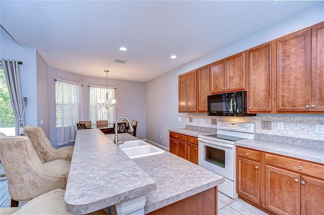 kitchen featuring a breakfast bar area, a center island with sink, a wealth of natural light, and white electric stove