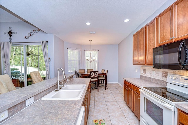 kitchen featuring decorative backsplash, sink, electric range, decorative light fixtures, and a chandelier