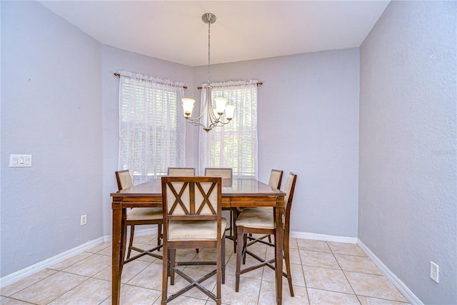 tiled dining room with a healthy amount of sunlight and a chandelier