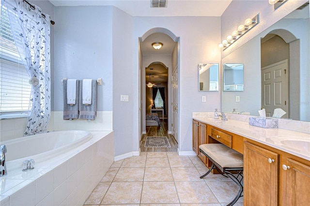 bathroom featuring vanity, tiled bath, tile patterned floors, and ceiling fan