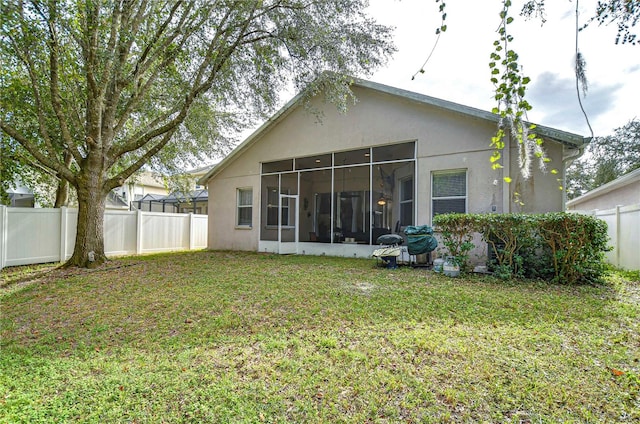 rear view of property with a yard and a sunroom