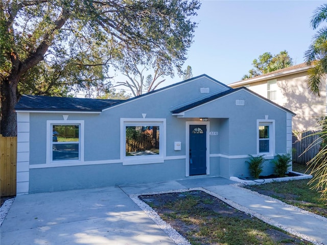 ranch-style home featuring fence and stucco siding