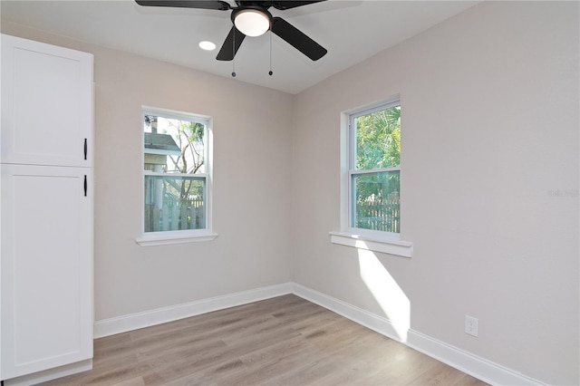 unfurnished room with baseboards, light wood-style flooring, and a healthy amount of sunlight