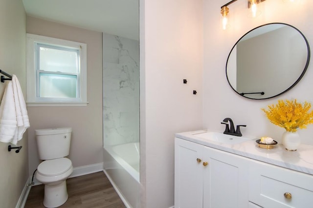 bathroom featuring toilet, baseboards, wood finished floors, and vanity