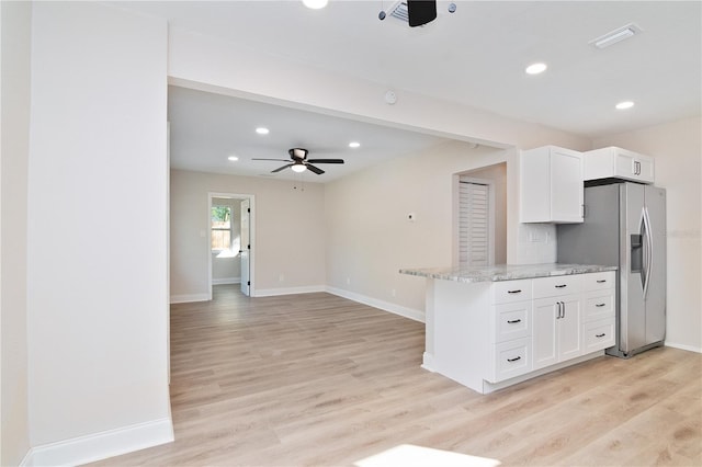 kitchen with white cabinets, stainless steel fridge with ice dispenser, light wood-style flooring, light stone counters, and open floor plan