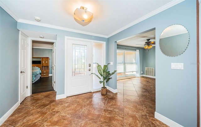 foyer entrance with ornamental molding and ceiling fan