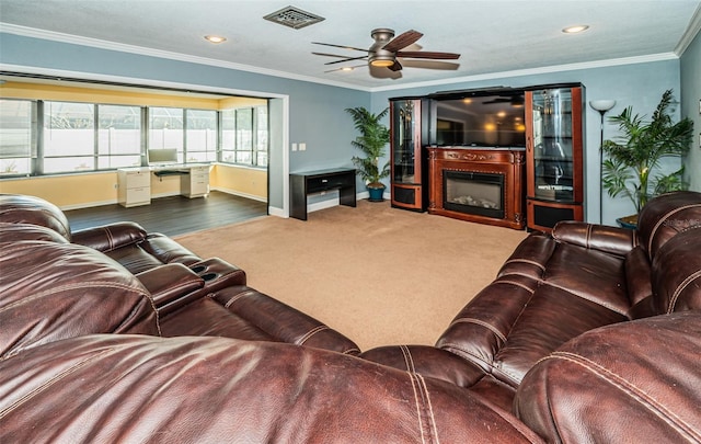 carpeted living room with ornamental molding and ceiling fan