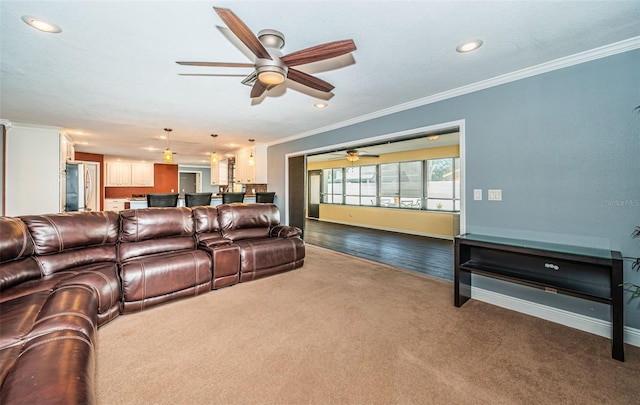 carpeted living room featuring ornamental molding and ceiling fan