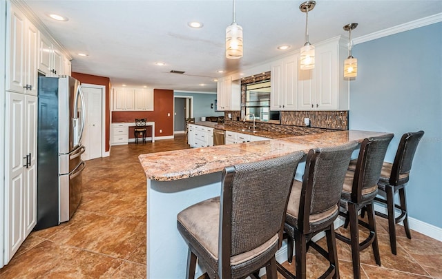 kitchen featuring appliances with stainless steel finishes, kitchen peninsula, decorative light fixtures, and white cabinets