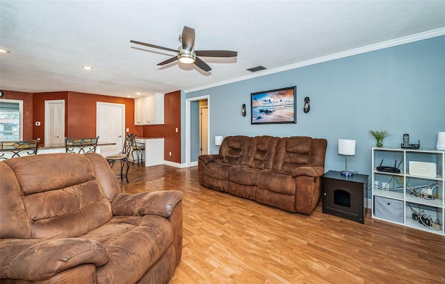 living room with crown molding, light hardwood / wood-style flooring, and ceiling fan