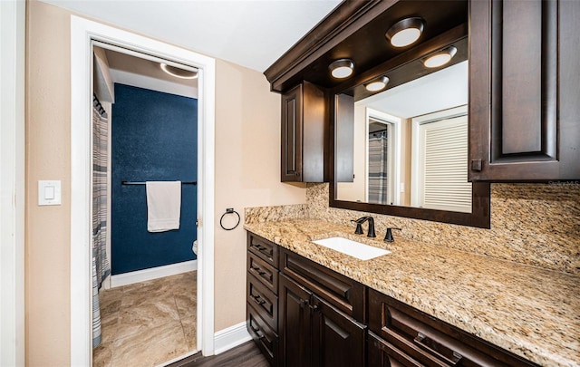 bathroom featuring backsplash, vanity, wood-type flooring, and toilet