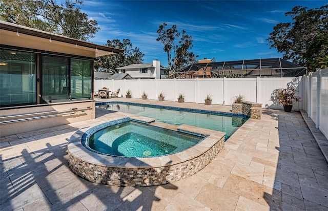 view of pool featuring a patio area, an in ground hot tub, and glass enclosure