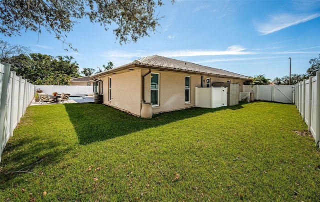 back of house featuring a patio area and a yard