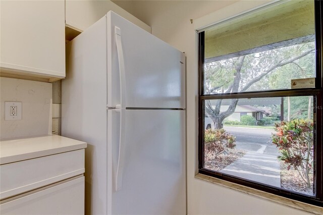 kitchen with white cabinetry and white fridge