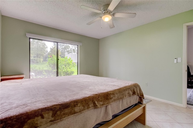 bedroom with a textured ceiling, light tile patterned floors, and ceiling fan