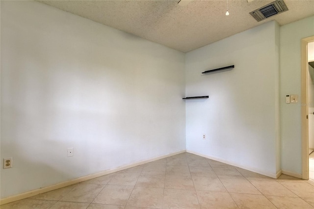 tiled spare room featuring a textured ceiling