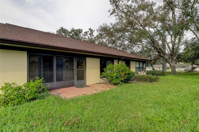 rear view of property featuring a lawn