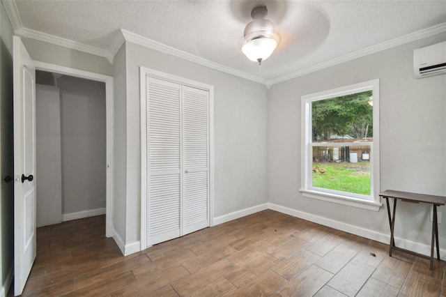 unfurnished bedroom with crown molding, an AC wall unit, ceiling fan, and a closet