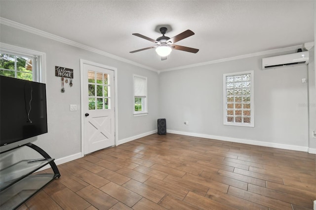 interior space with ornamental molding, an AC wall unit, a textured ceiling, and ceiling fan