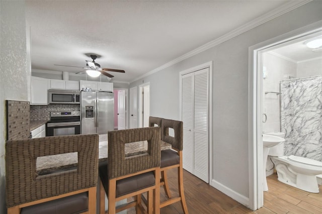 dining room with hardwood / wood-style floors, ornamental molding, and ceiling fan