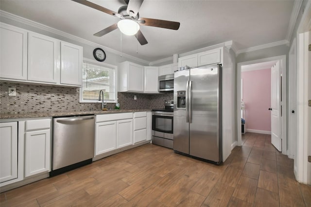 kitchen with stainless steel appliances, sink, white cabinets, and decorative backsplash